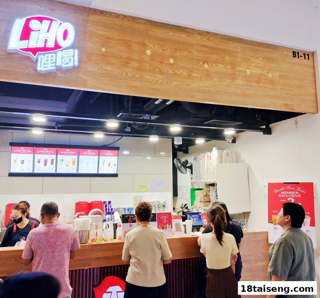 Customers queueing at the counter of a bustling LiHO TEA bubble tea shop.