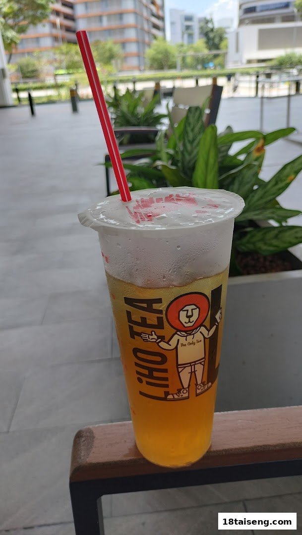 A refreshing LiHO TEA beverage with a red straw, featuring the brand's iconic lion logo.
