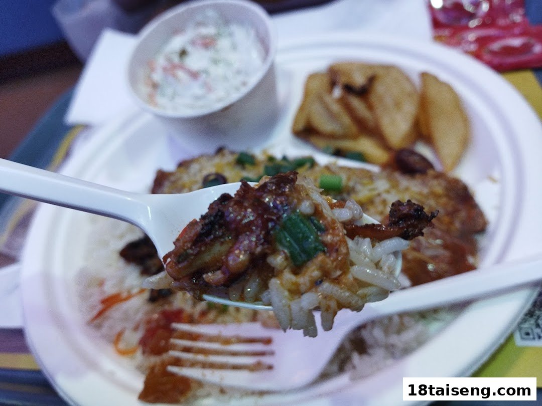 A close-up of a delicious meal featuring rice, meat, and sides on a white plate.