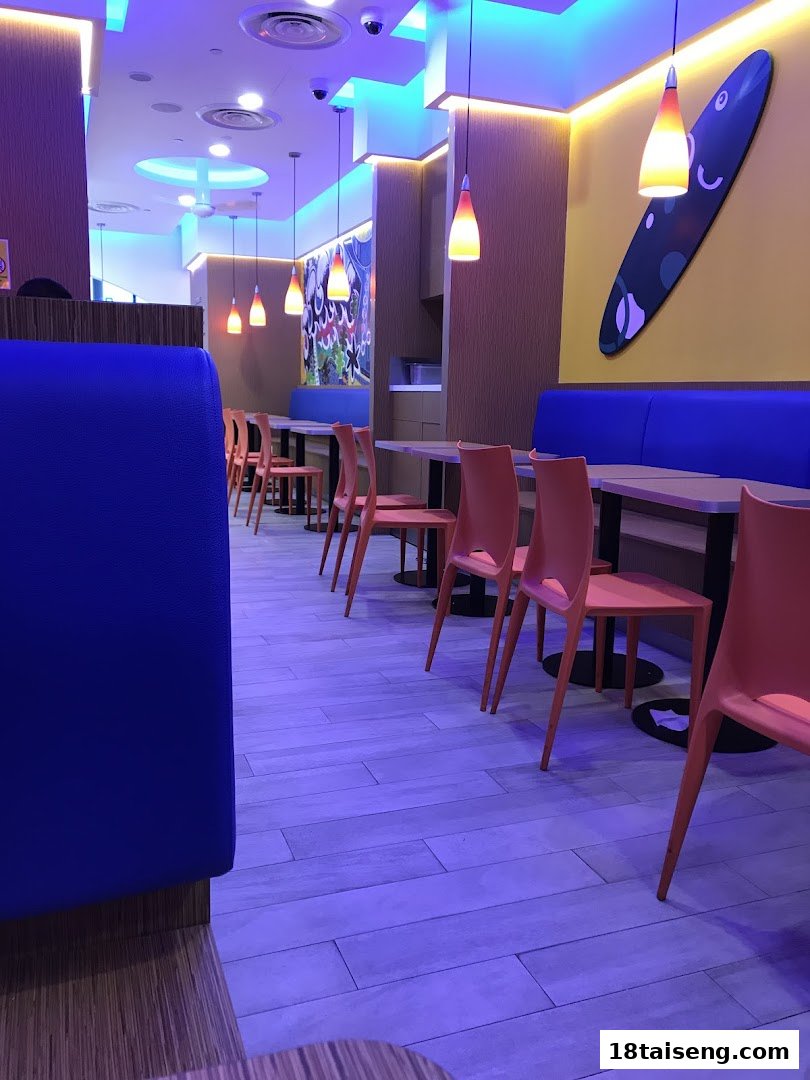 Vibrant interior of Long John Silver's, featuring blue booths, orange chairs, and surf-themed decor.