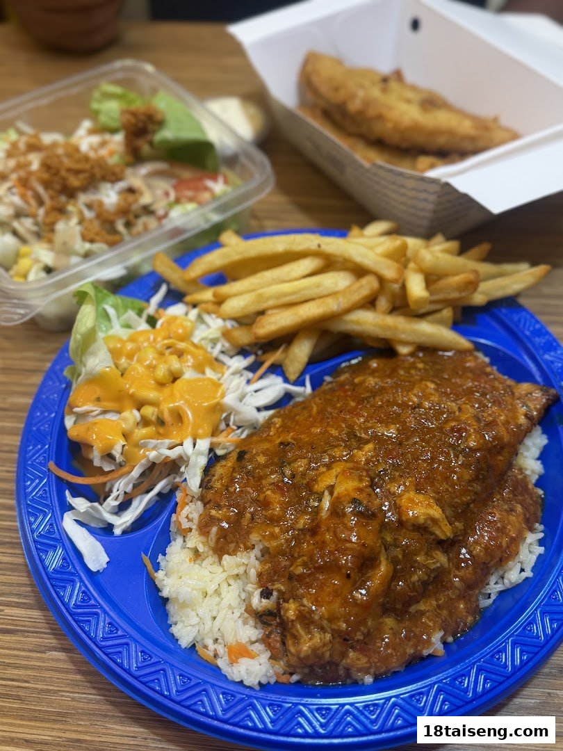 A close-up of a meal featuring fish, rice, fries, and salad on a blue plate.