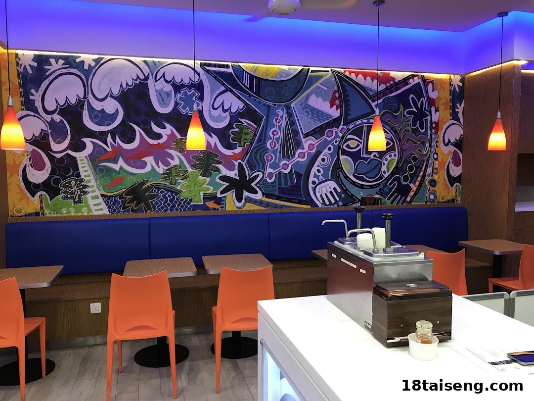 Vibrant interior of Long John Silver's with a colorful mural, blue booth seating, and orange chairs.