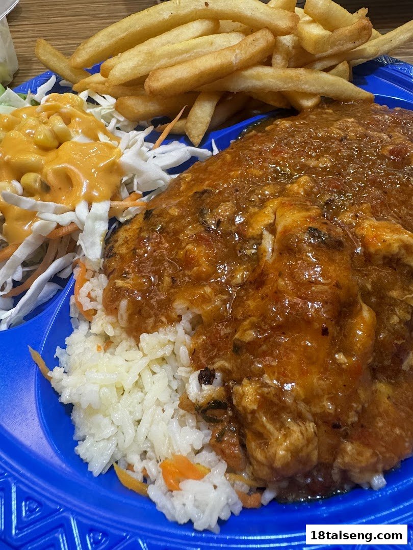 A vibrant meal featuring fish with sauce, rice, fries, and coleslaw on a blue plate.