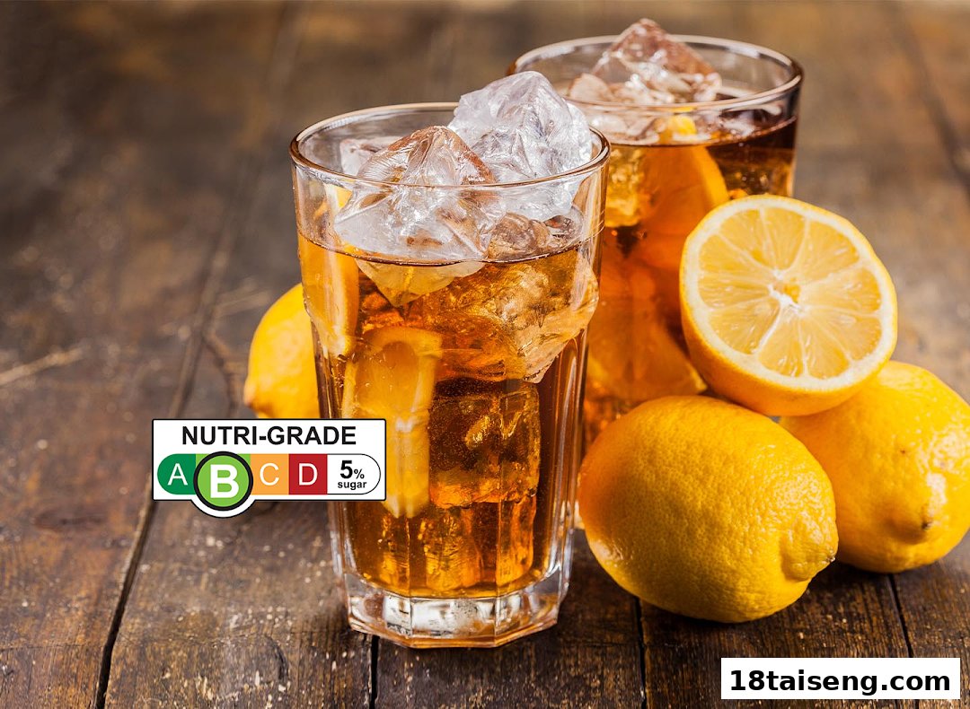 Two glasses of iced lemon tea with fresh lemons and a Nutri-Grade label on a wooden table.