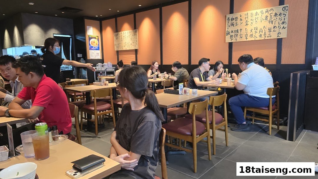 Customers dine inside Marutama Ramen, enjoying the vibrant atmosphere and delicious food.