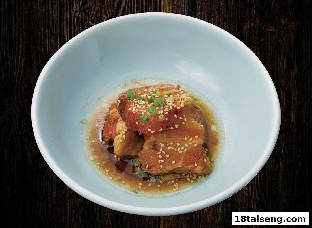 A light blue bowl holds tender braised pork belly, garnished with sesame seeds and green onions in a savory sauce.