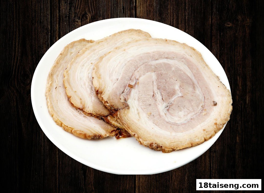 Close-up of several slices of tender chashu (braised pork belly) served on a white plate.