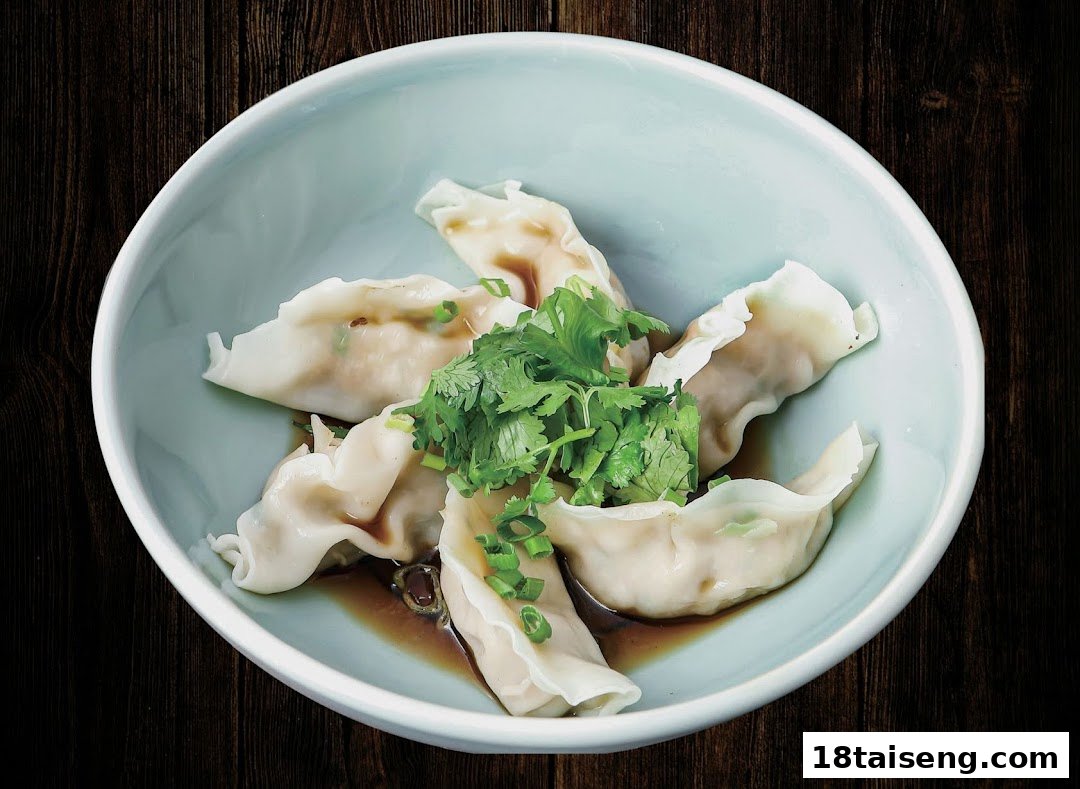 A light blue bowl filled with steamed dumplings, garnished with fresh cilantro and green onions, in a savory sauce.