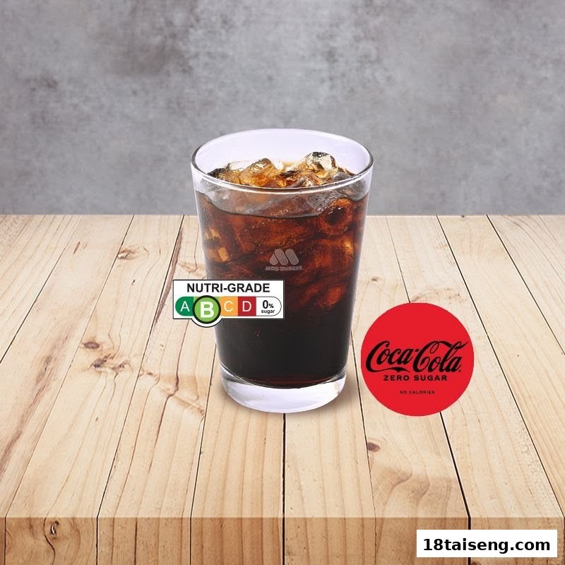 A glass of Coca-Cola Zero Sugar with ice, featuring Nutri-Grade A, on a wooden table.