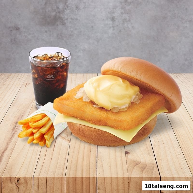 A delicious fish burger with cheese, fries, and a refreshing cola drink on a wooden table.