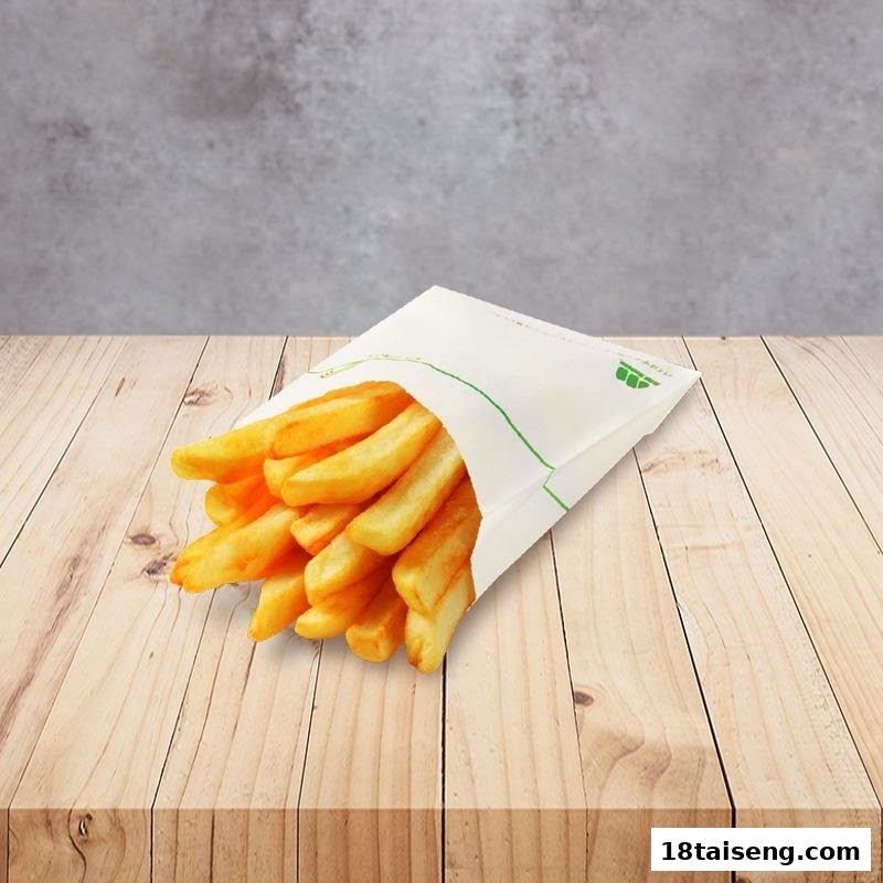 A paper bag filled with golden french fries rests on a light wooden table.