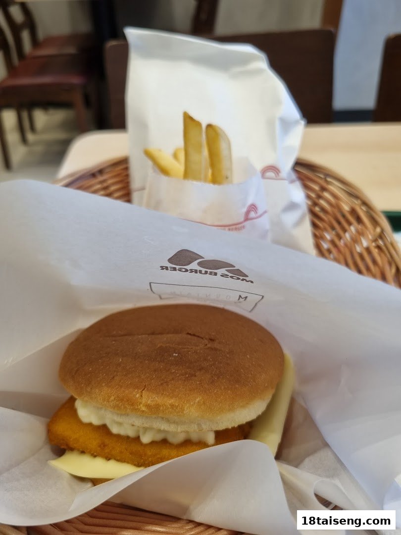 A delicious MOS Burger fish burger and golden fries served in a basket.