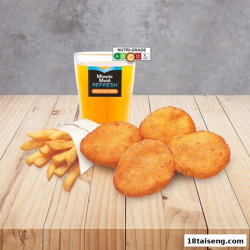 A meal set featuring golden nuggets, crispy fries, and a refreshing orange drink on a wooden table.