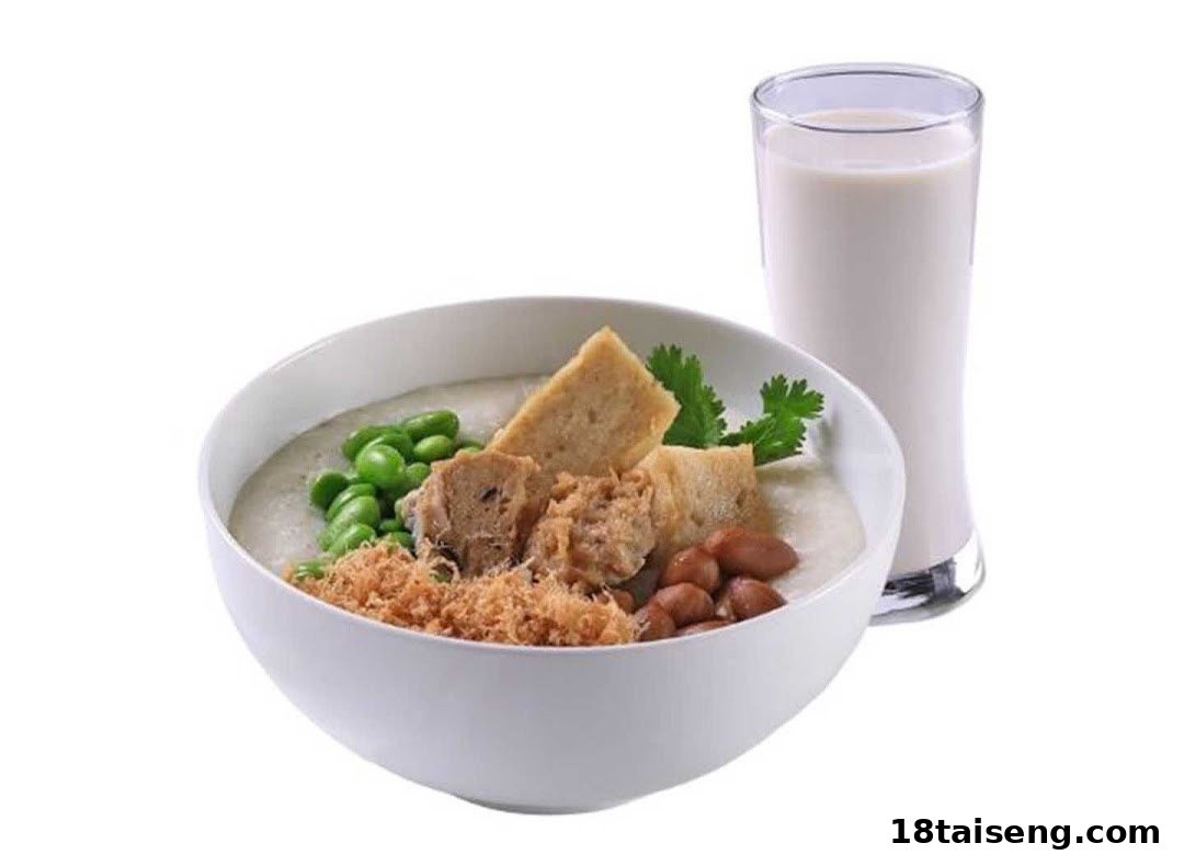 A bowl of savory porridge with various toppings and a glass of soy milk.