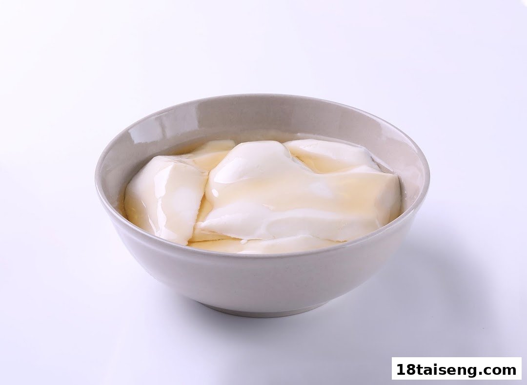 A bowl of smooth tofu pudding drizzled with golden syrup.
