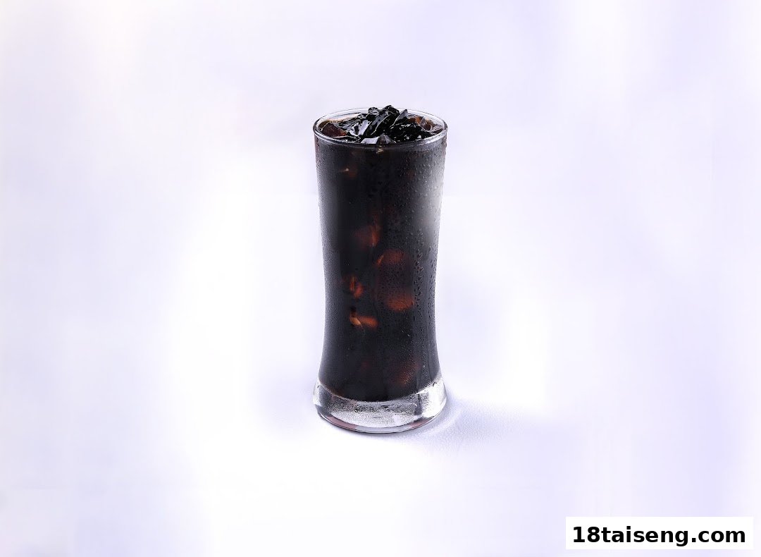 A tall glass of iced dark beverage with jelly toppings, likely from Mr Bean.