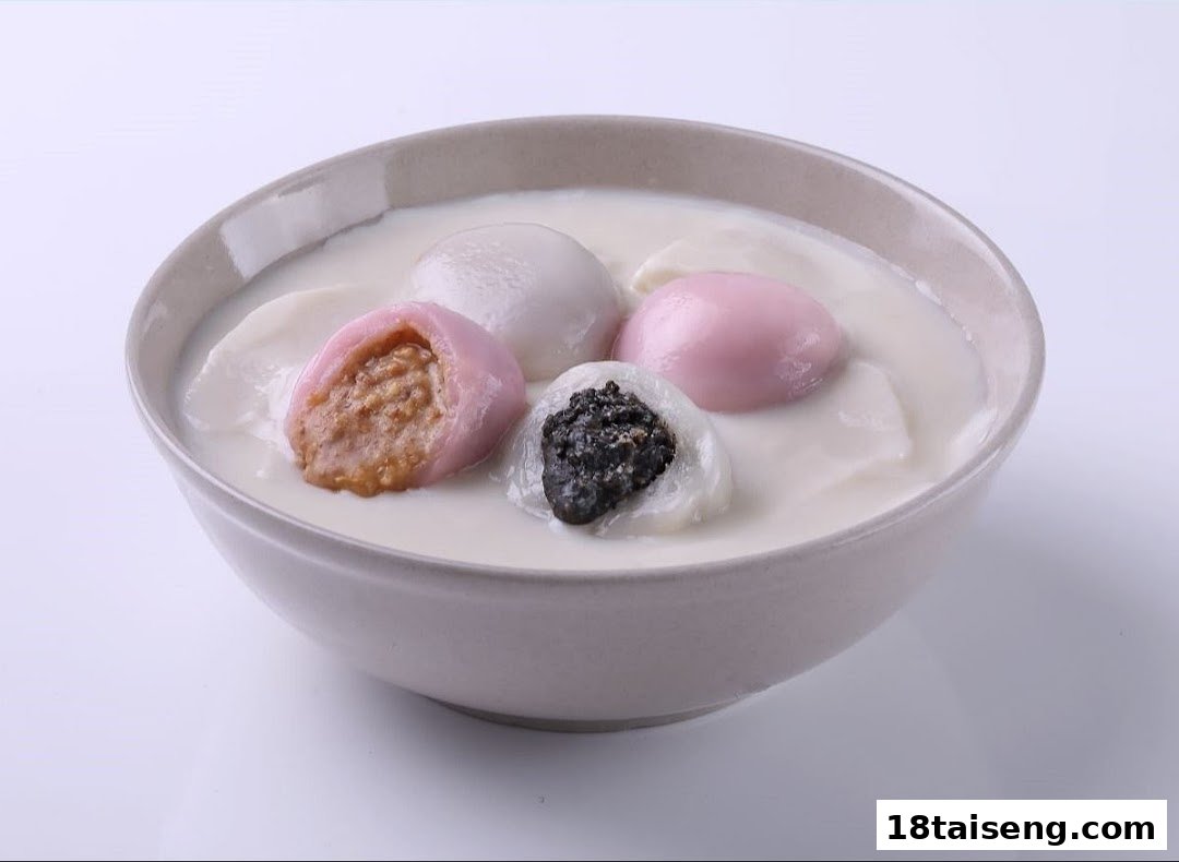 A bowl of colorful tangyuan-like dumplings with various fillings in a creamy white liquid.