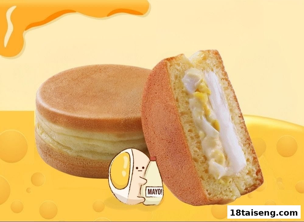 A whole and a sliced pancake-like dessert with creamy filling, featuring a cartoon character.