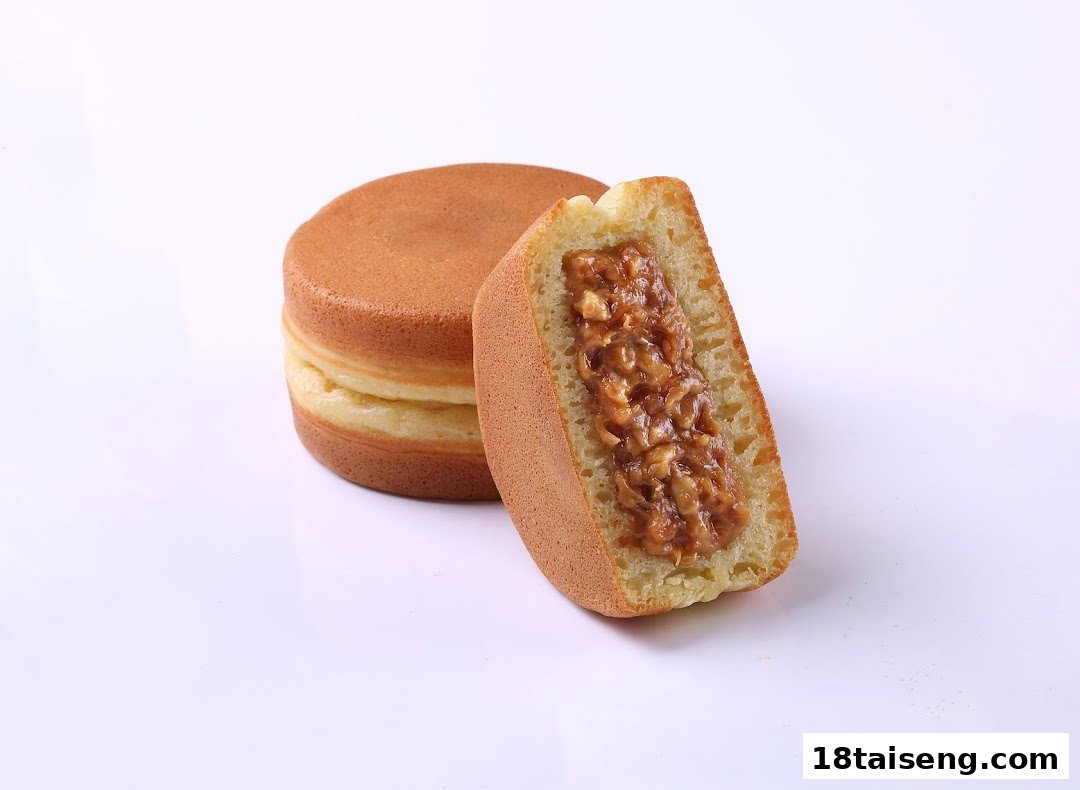 A whole and a cut Japanese pancake (Dorayaki style) revealing a sweet, nutty filling.