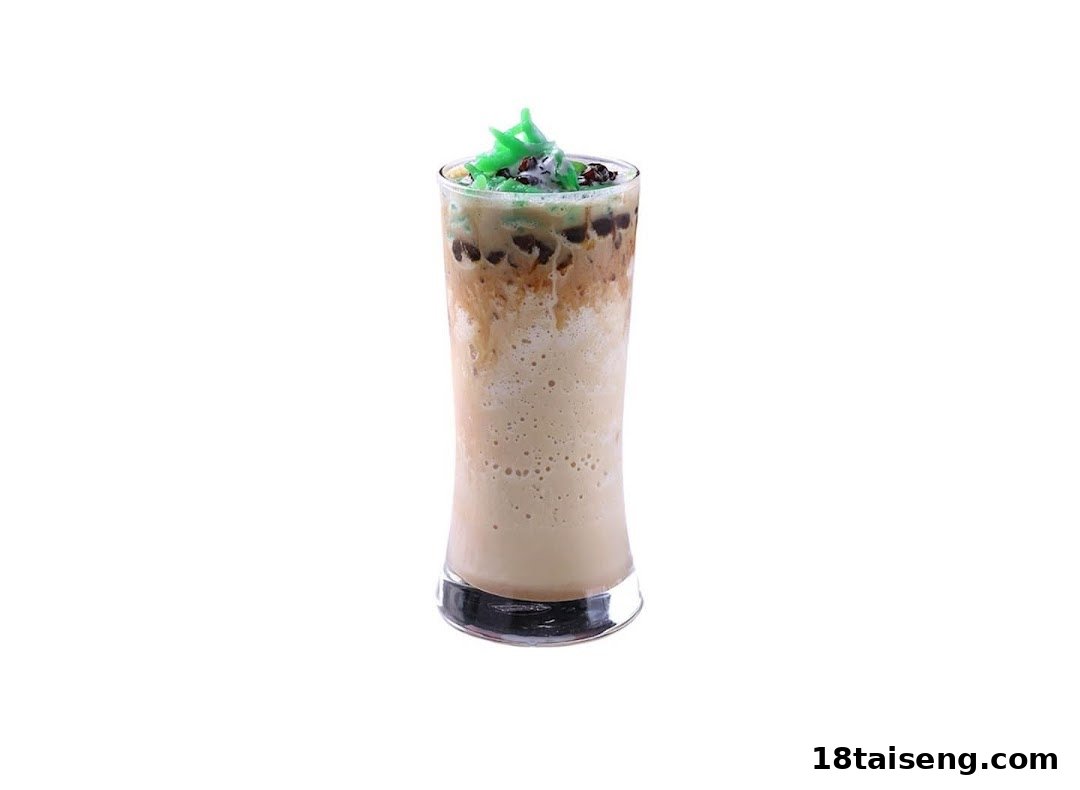 A tall glass of blended beverage with green jelly and dark toppings, isolated on white.