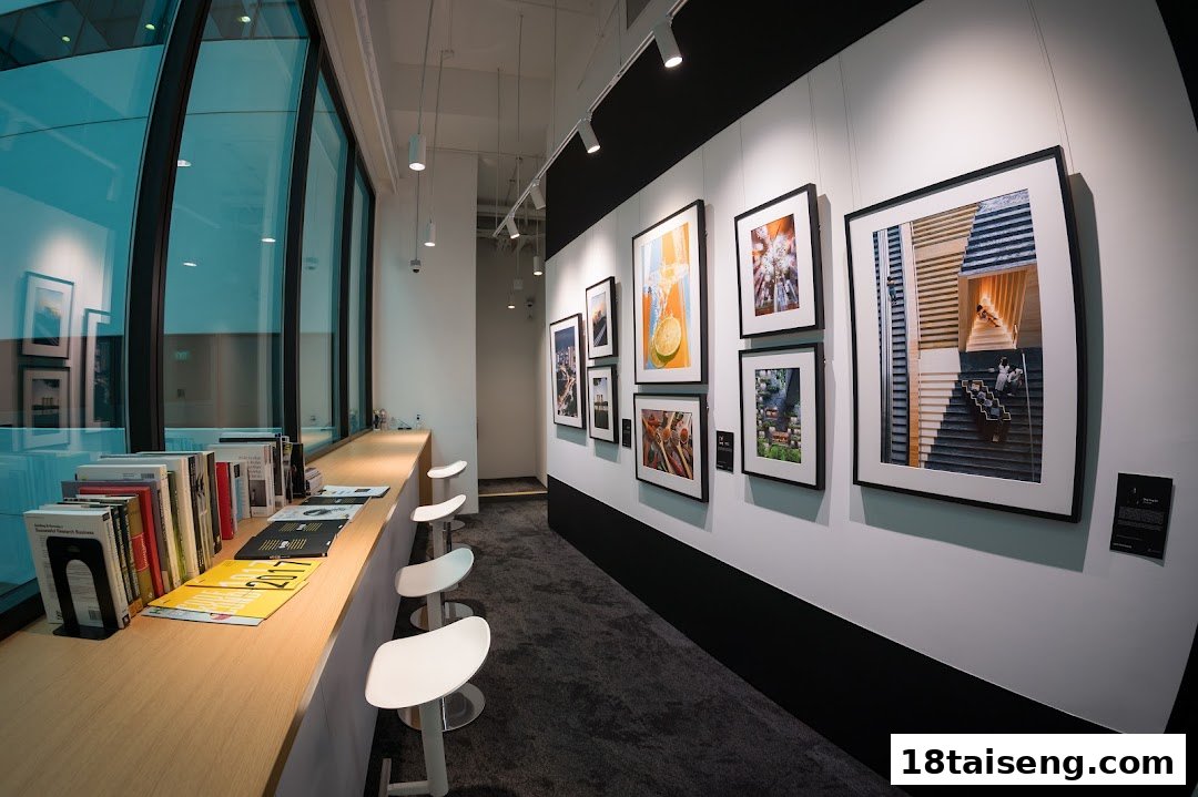 An interior view of Nikon Singapore featuring a gallery wall with framed photographs and a reading counter with books.