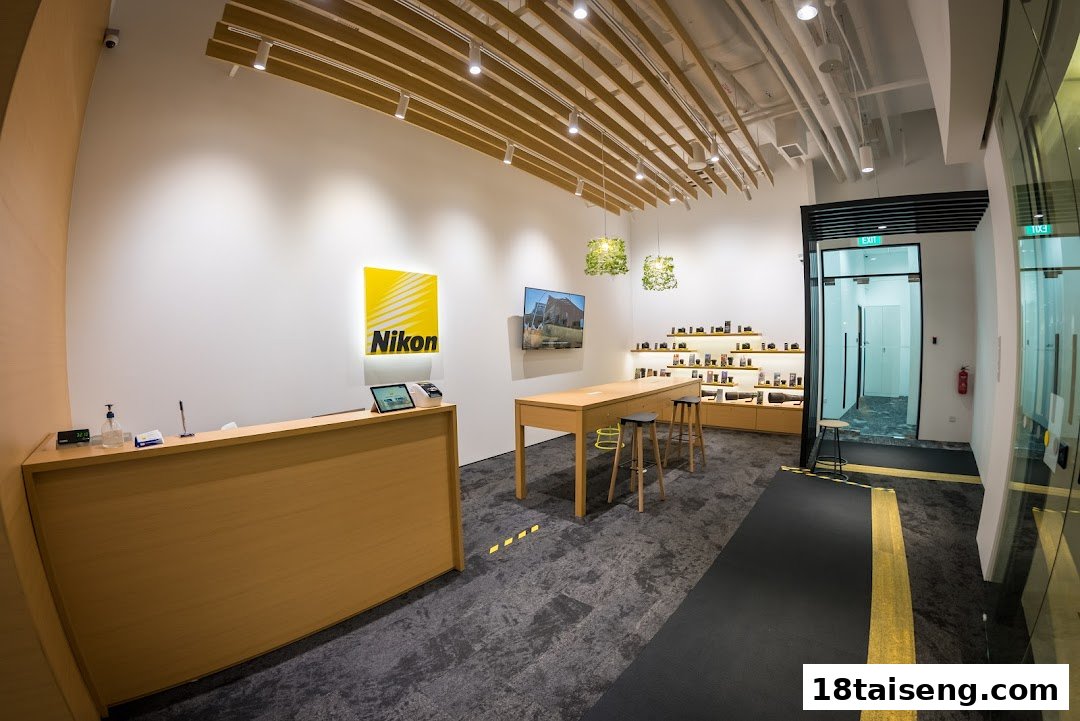 An interior view of the Nikon Singapore store, featuring the brand logo, display shelves with cameras, and a customer service counter.
