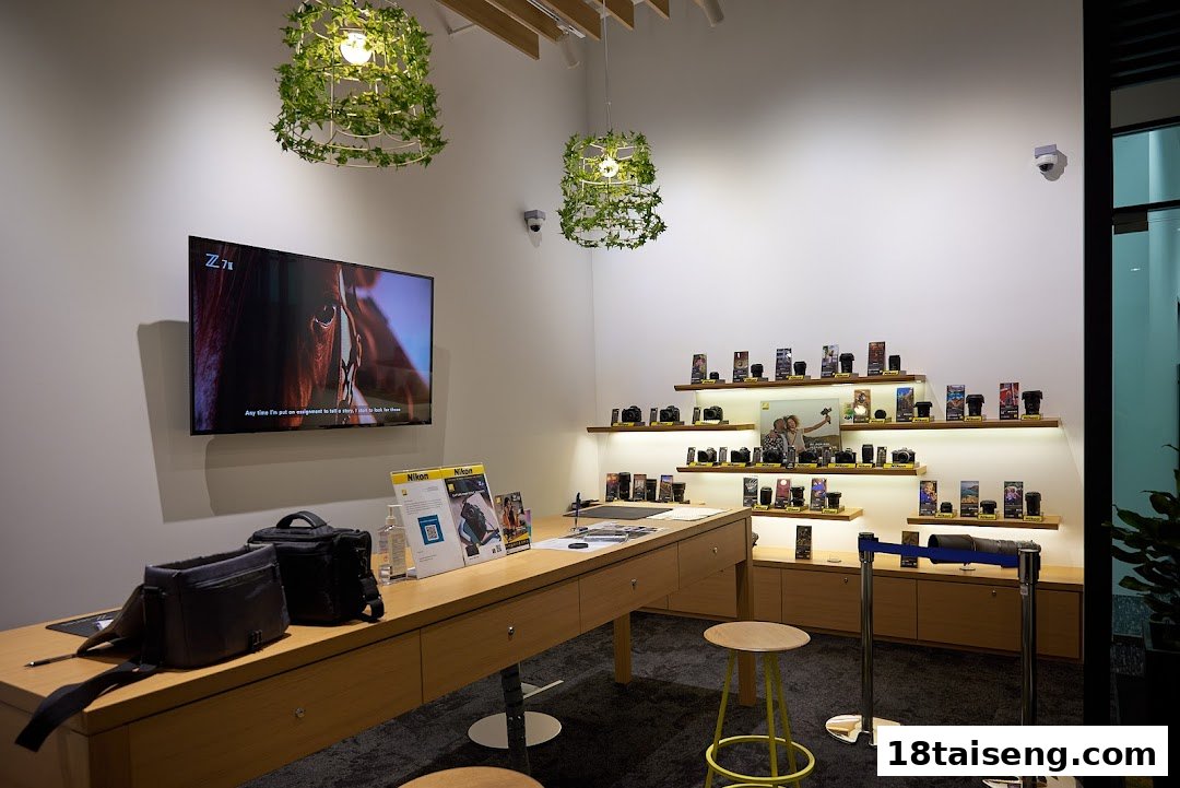 Interior view of Nikon Singapore store showcasing cameras, lenses, and accessories on display shelves and a counter.