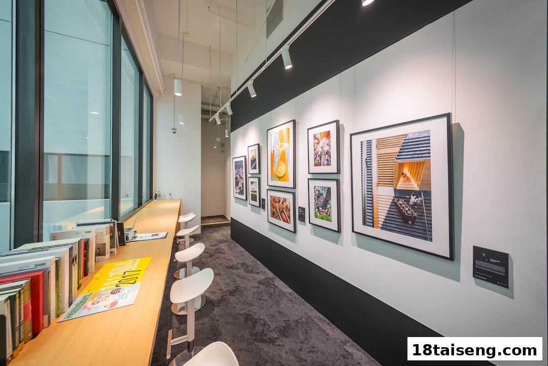An interior view of Nikon Singapore featuring a photo gallery wall, a long counter with stools, and large windows.