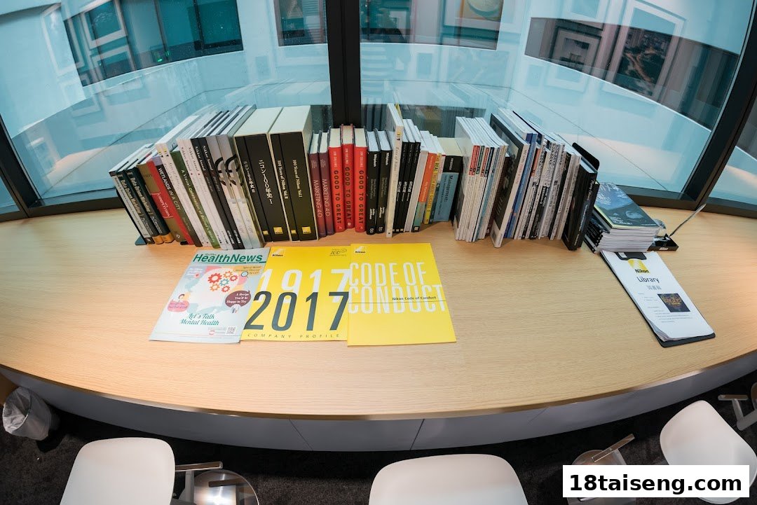 A comfortable lounge area at Nikon Singapore featuring a collection of books and magazines on a wooden counter.