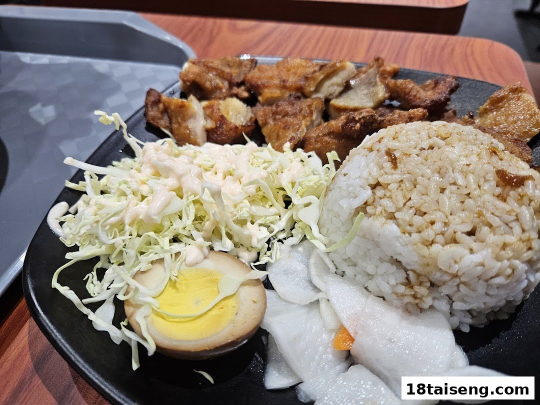 A delicious Taiwanese meal featuring fried chicken, rice, cabbage, and a tea egg.
