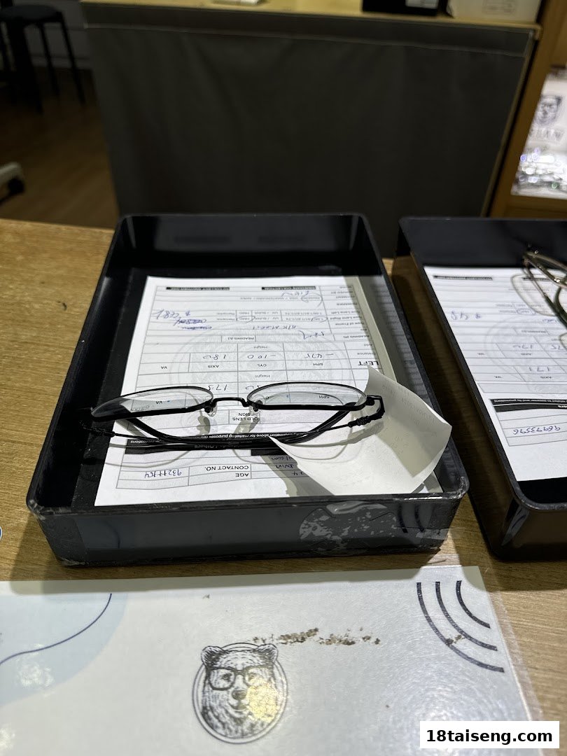 Eyeglasses and forms on a counter, indicating an optical service or eye examination.