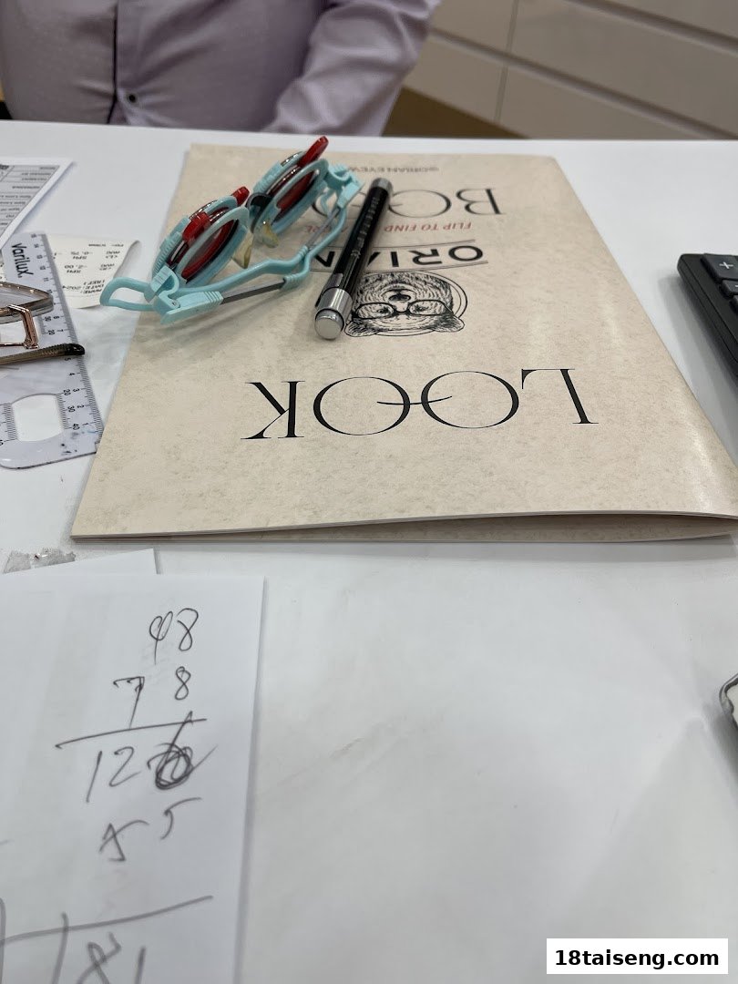 Optical testing equipment, documents, and calculations on a table at Orian.