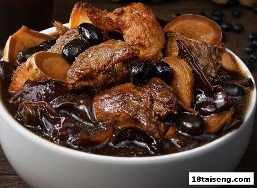 A close-up of a rich, dark vegetarian stew with mock meat, mushrooms, and black beans in a white bowl.