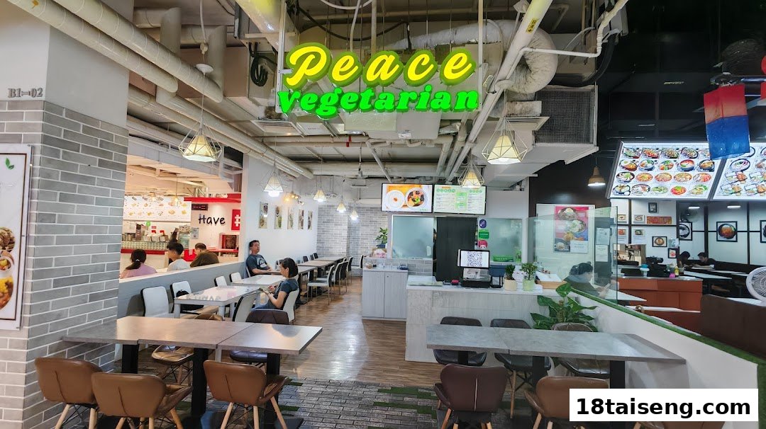 Interior view of Peace Vegetarian restaurant with seating, counter, and customers.