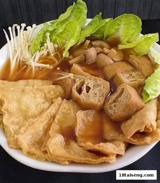 A close-up of a vegetarian dish with mushrooms, tofu puffs, and greens in savory broth.