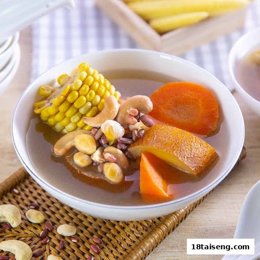 A vibrant bowl of vegetarian soup with corn, carrots, cashews, and mixed beans.