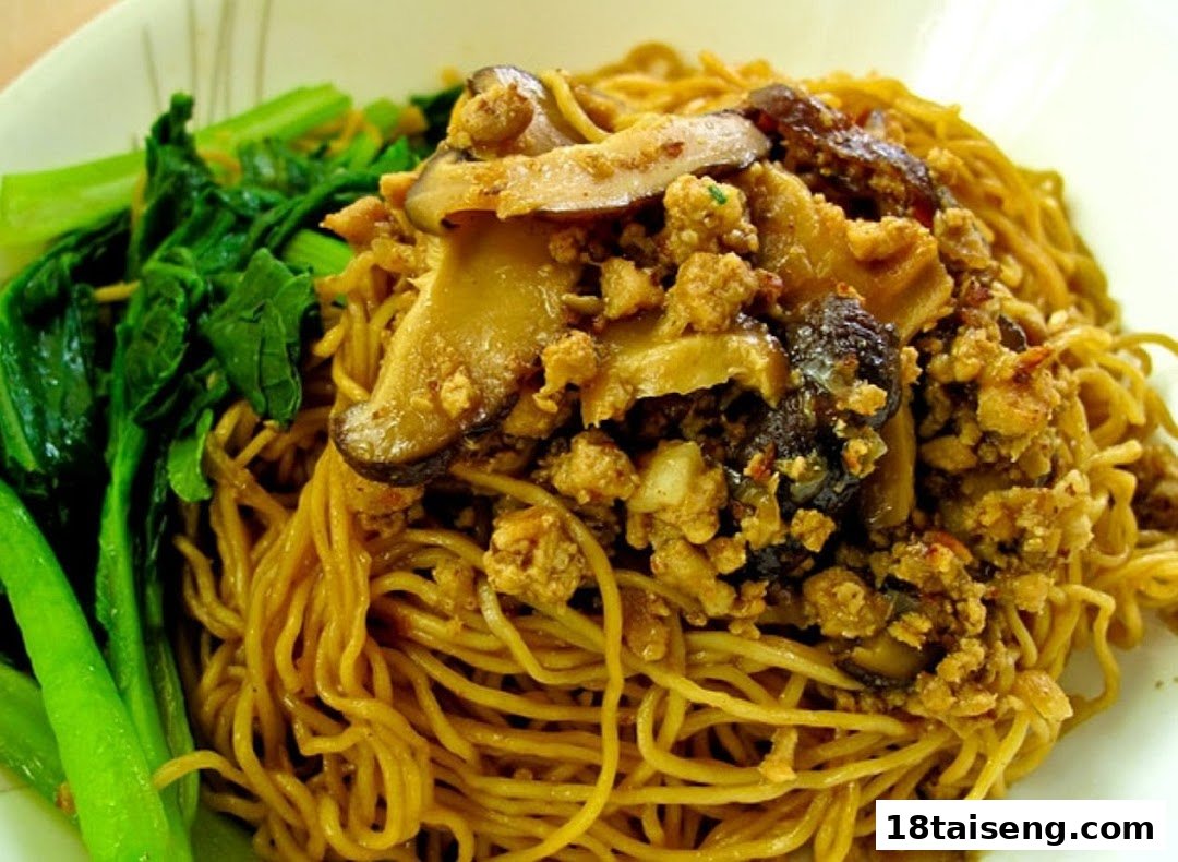A close-up of vegetarian noodles with mushrooms, minced plant-based protein, and green vegetables.