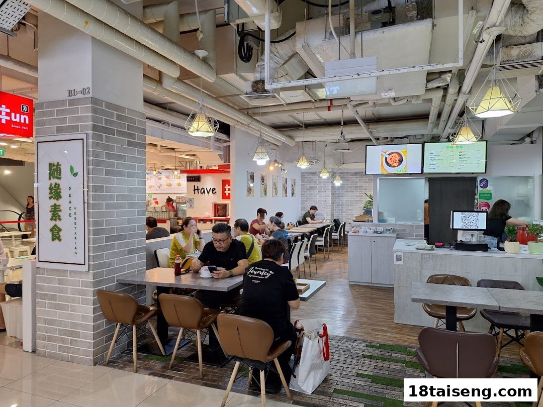An interior view of Peace Vegetarian restaurant with customers dining and a service counter.
