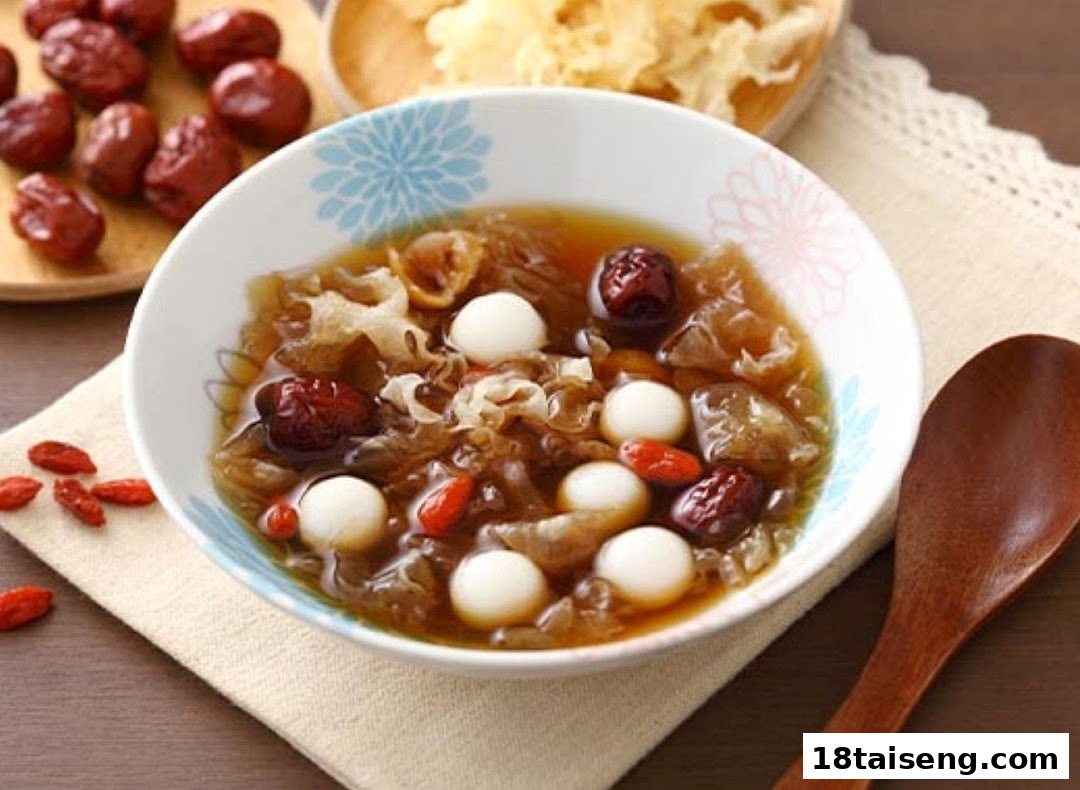 A bowl of traditional Chinese dessert with red dates, goji berries, white fungus, and tangyuan.