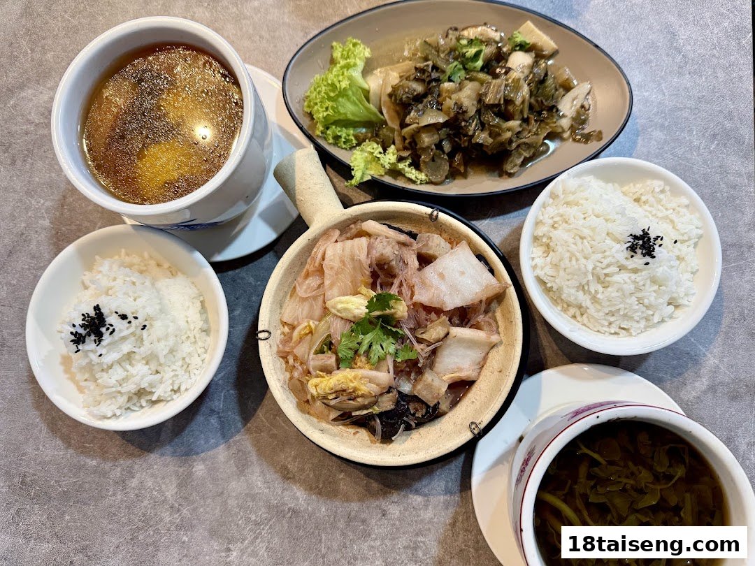 A delicious vegetarian meal featuring rice, two soups, and two savory vegetable dishes on a grey table.