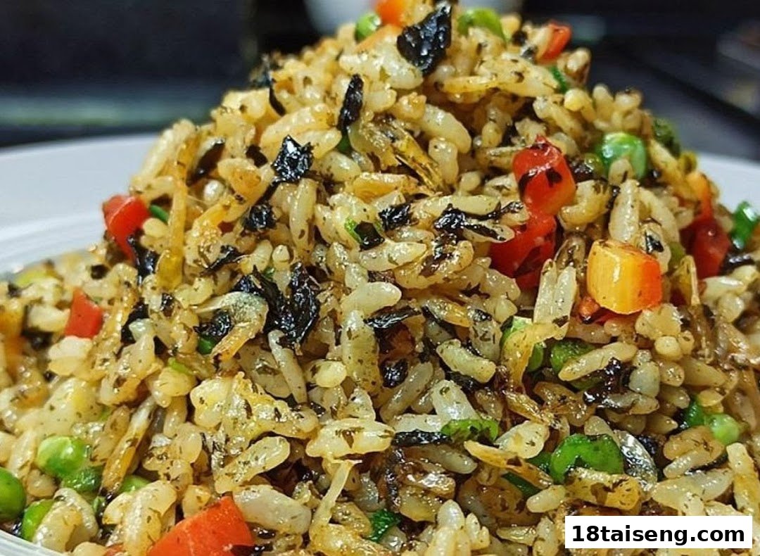 A close-up of flavorful vegetarian fried rice with colorful vegetables and herbs.