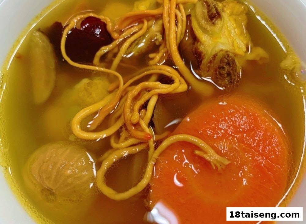 A close-up of a nourishing clear soup with cordyceps, carrots, red dates, and other wholesome ingredients.