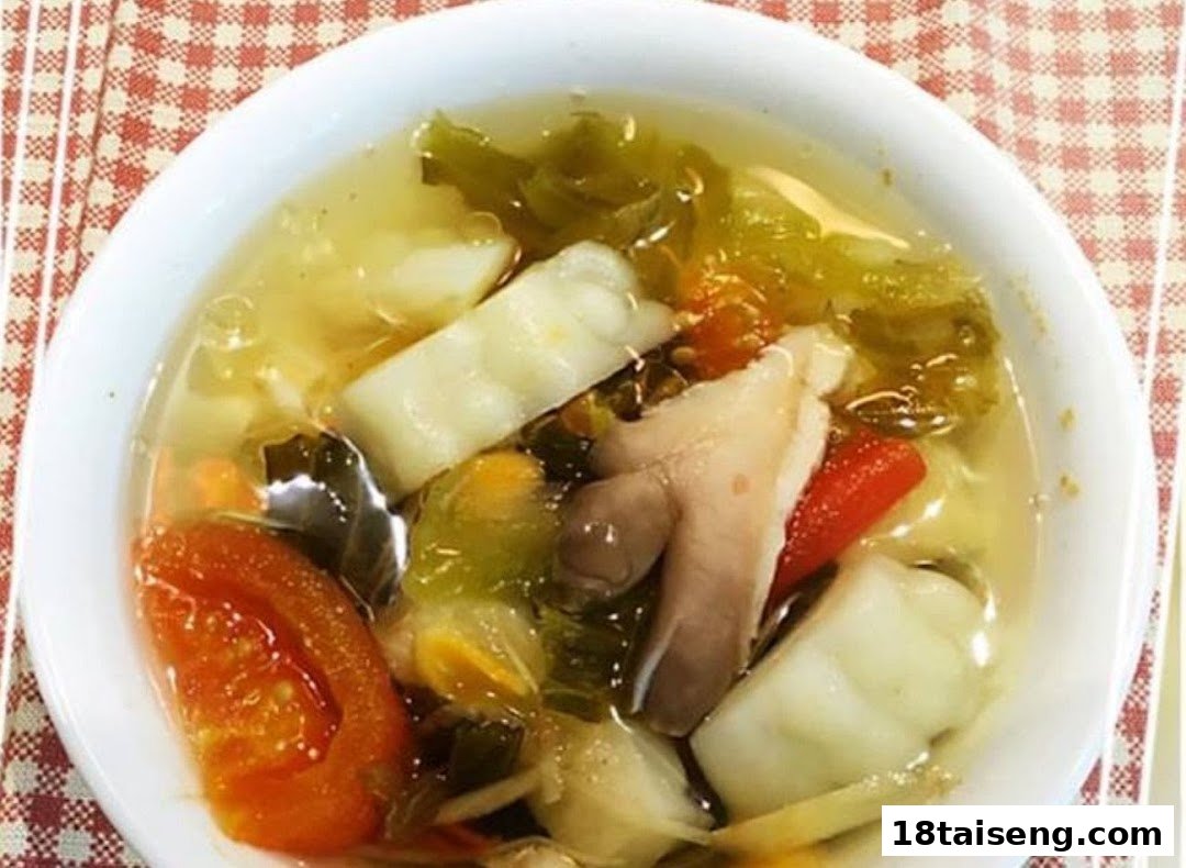A close-up of a clear vegetarian soup with various vegetables, mushrooms, and mock meat.