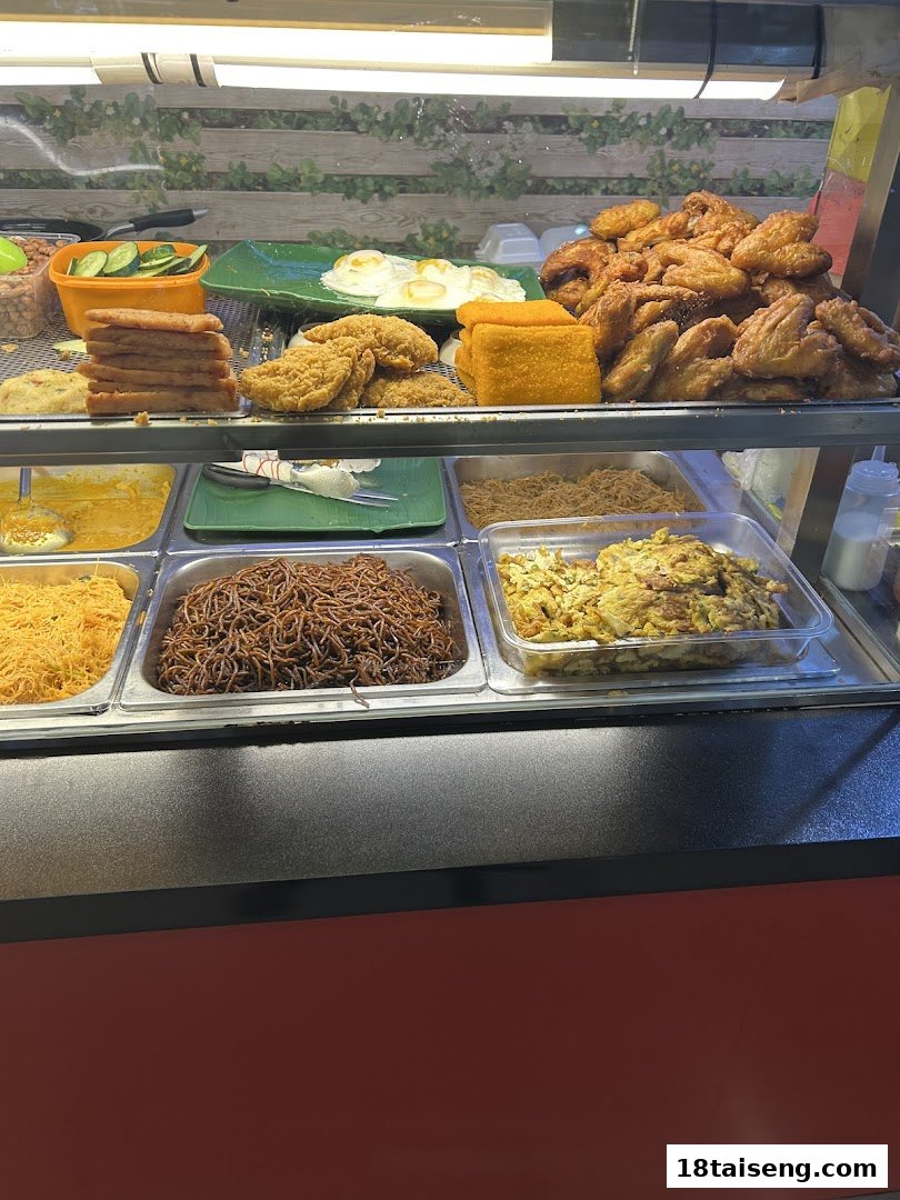 A vibrant display of freshly prepared hot food, including noodles, fried chicken, and eggs.