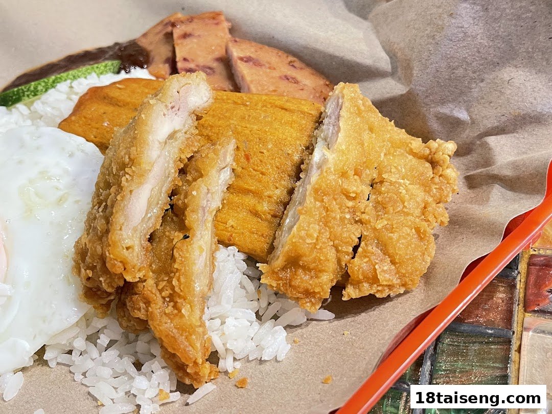 A close-up of crispy fried chicken, rice, and other components of a delicious meal.