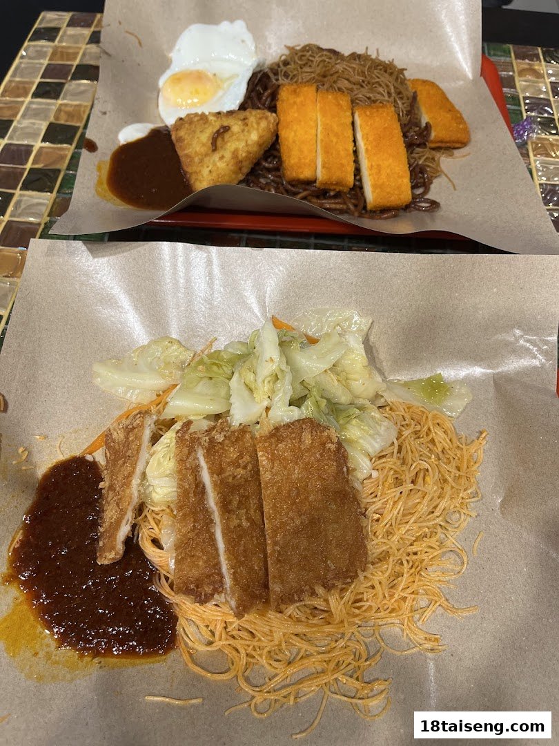 Two delicious noodle dishes with fried sides, eggs, and vegetables, served on paper-lined trays.