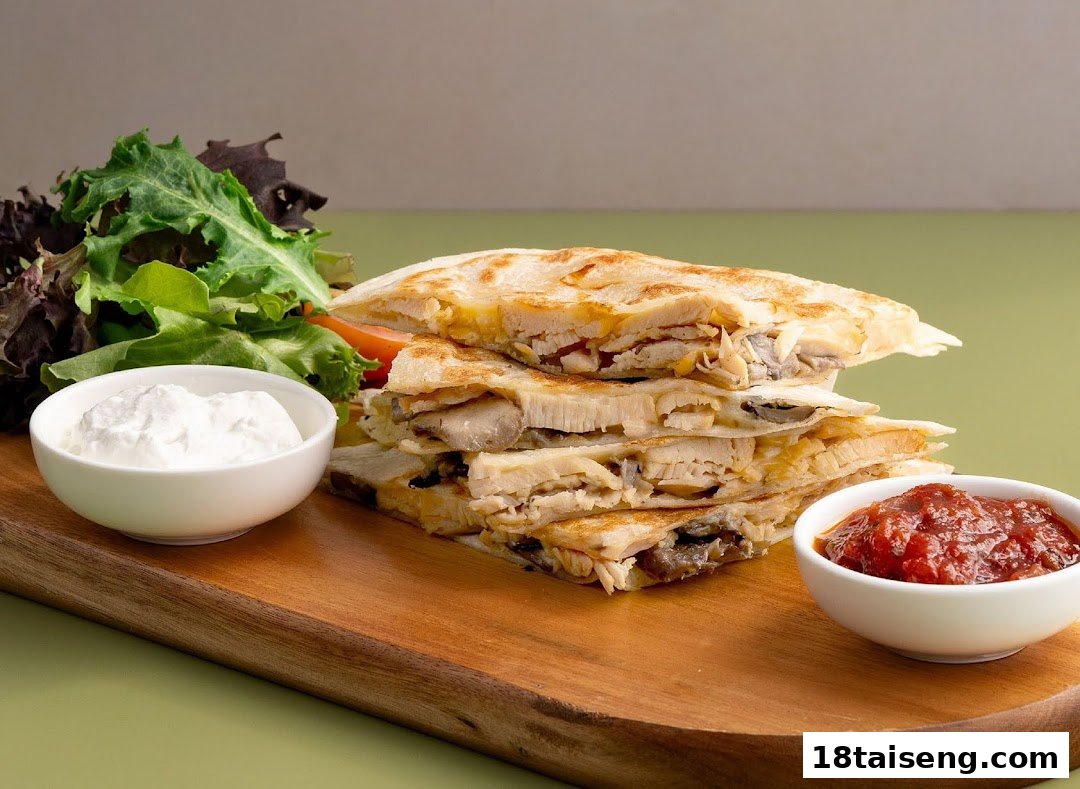 A stack of golden-brown quesadillas with chicken and cheese, served with fresh salad, sour cream, and salsa.