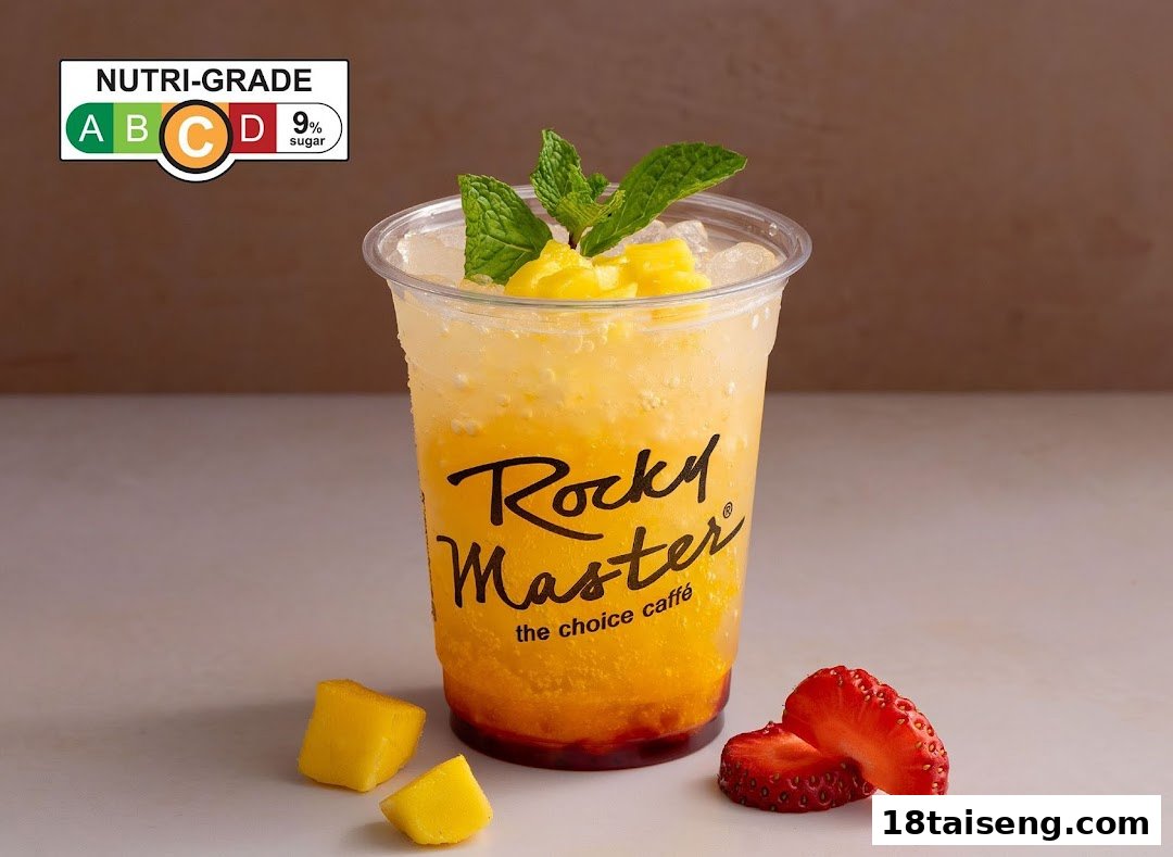 A vibrant mango-based drink from Rocky Master, garnished with fresh mint, mango chunks, and strawberries.