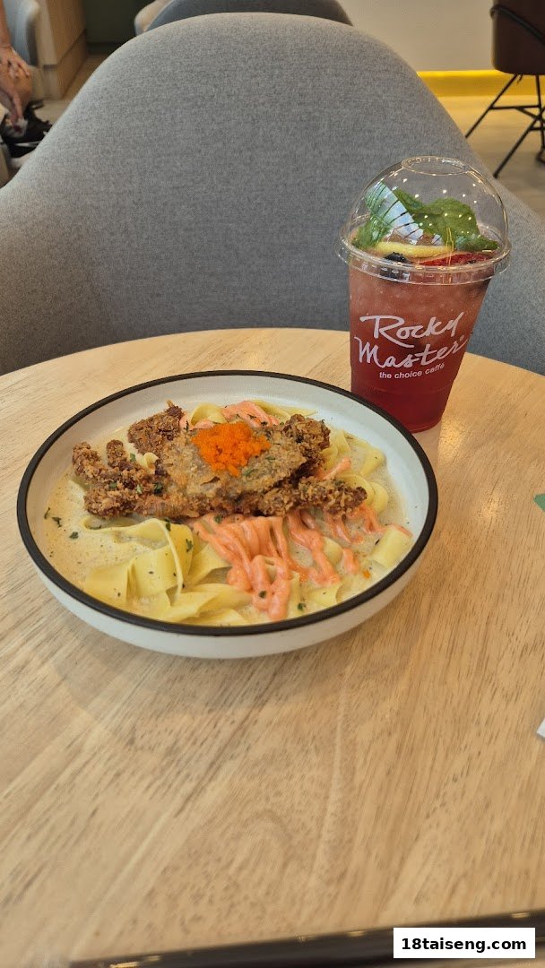 A plate of pasta with fried soft-shell crab and a refreshing berry drink on a wooden table.
