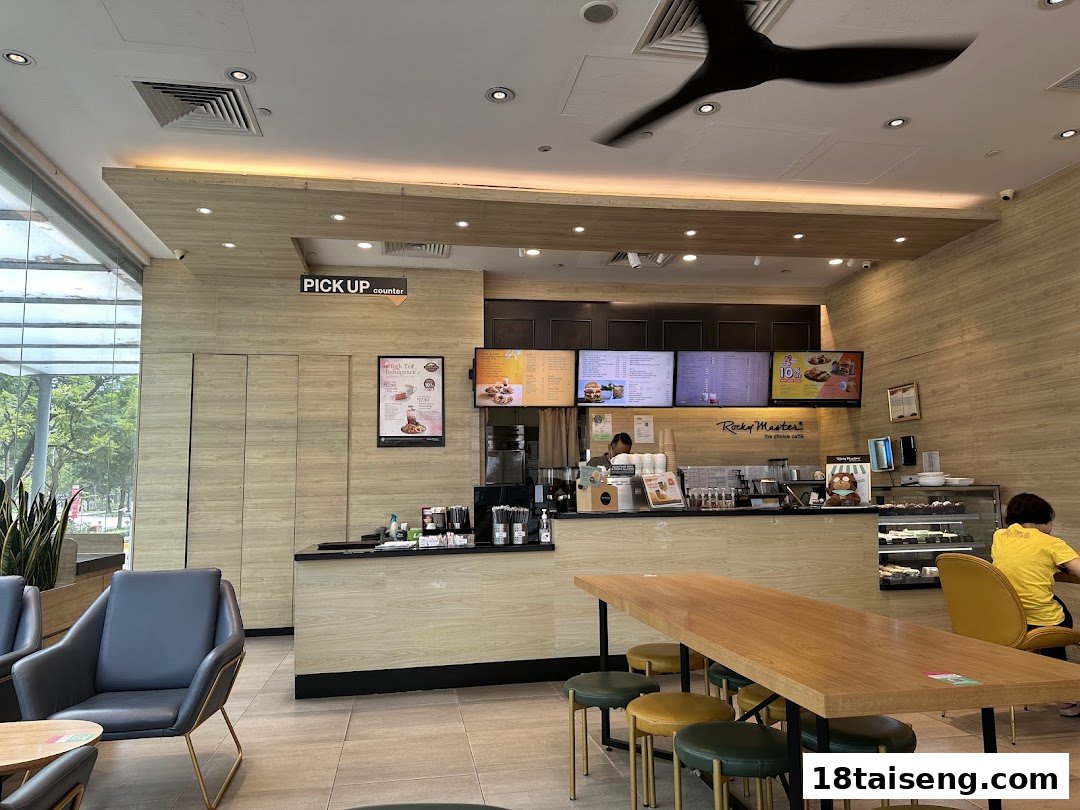 Interior view of Rocky Master cafe, featuring the service counter, comfortable seating, and digital menu displays.